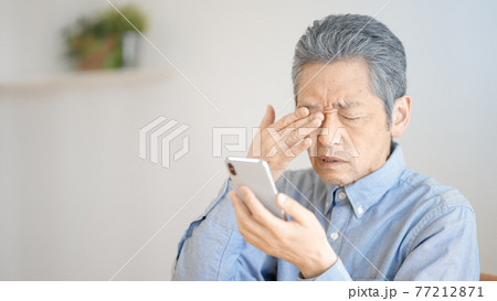 スマートフォンを使う老眼のシニア男性 スマートフォンを使う老眼のシニア男性 77212871