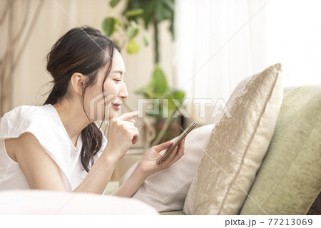 自宅でスマホを持つ女性 77213069
