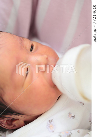 新生児の女の子にミルクを飲ませるママの写真素材