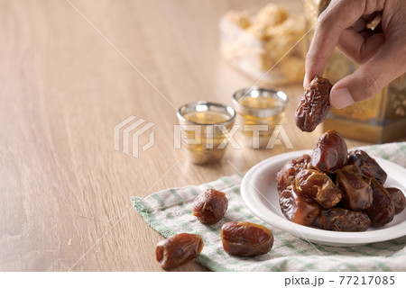 Eating dried dates.Traditional arabic food for iftar Eating dried dates.Traditional arabic food for iftar 77217085