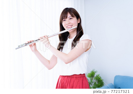 リビングでフルートを吹く女性 リビングでフルートを吹く女性 77217321