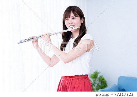 リビングでフルートを吹く女性 リビングでフルートを吹く女性 77217322