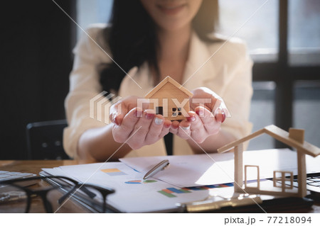 Insurance agent protecting wooden model of the house. Property insurance concept. Insurance agent protecting wooden model of the house. Property insurance concept. 77218094