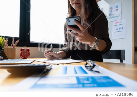 Young accountant marketing consultants and using calculator app by smartphone to analyze sales growth in the global workplace market. accounting concept Young accountant marketing consultants and using calculator app by smartphone to analyze sales growth in the global workplace market. accounting concept 77218096