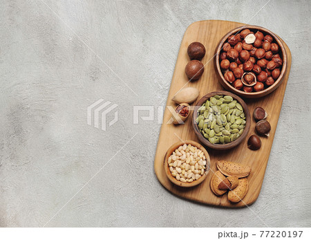 Assorts nuts on board closeup. 77220197