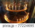 並んだ火の灯ったロウソク 77224695