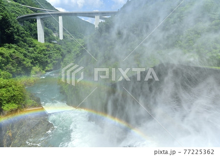 奥秩父滝沢ダムの放流の水煙に架かる虹と雷電廿六木橋 77225362
