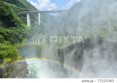 奥秩父滝沢ダムの放流の水煙に架かる虹と雷電廿六木橋 奥秩父滝沢ダムの放流の水煙に架かる虹と雷電廿六木橋 77225365
