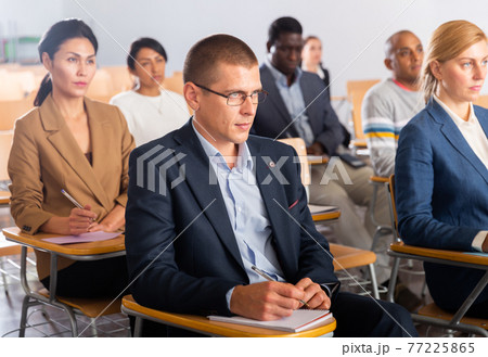 Focused man listening to lecture at conference Focused man listening to lecture at conference 77225865