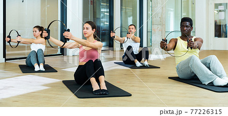 Sporty people doing pilates exercises with Magic Circles 77226315