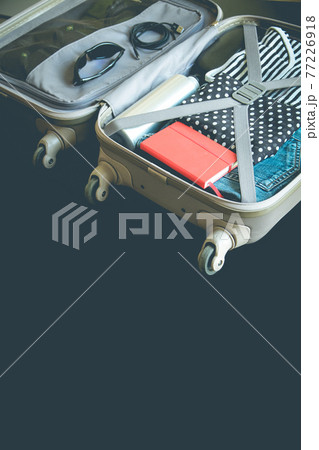 Open suitcase full of clothes isolated on black background Open suitcase full of clothes isolated on black background 77226918