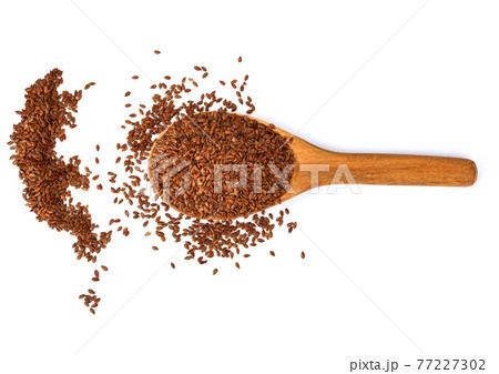 Flax seeds in a wooden spoon isolated on white background. Flax seeds in a wooden spoon isolated on white background. 77227302