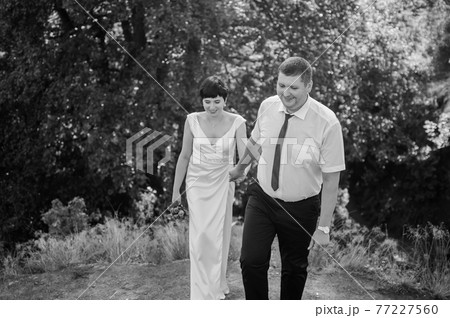 Newlyweds hold hands on the background of the forest Newlyweds hold hands on the background of the forest 77227560