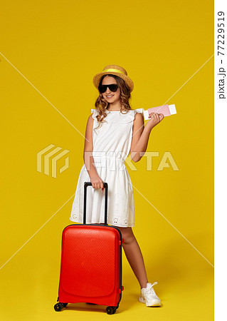 teenager girl in hat and sunglasses with red suitcase 77229519