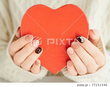 ハートの贈り物をするアジア人女性の手元 77231540