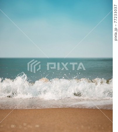 Sand Beach and Hard Wave on Summer Sunny Day. Blue Ocean and Sky as background. Low angle View. Focus on Water Ripple Swash 77233037