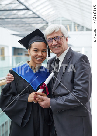 Woman posing with professor at graduation Woman posing with professor at graduation 77233230