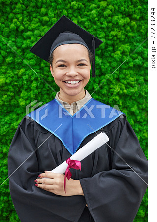 Woman in graduation gown outdoors 77233244
