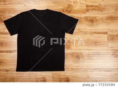 Black shortsleeve cotton tshirt on a wooden backgronud Black shortsleeve cotton tshirt on a wooden backgronud 77233584