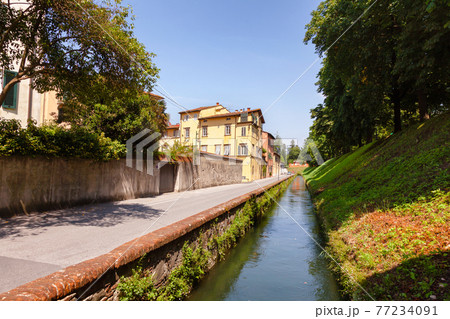 Lucca old town cityscape with canal along fortified city wall Tuscany Italy Lucca old town cityscape with canal along fortified city wall Tuscany Italy 77234091
