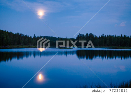 Summer night landscape with moonlight reflects in a lake Telemark Norway 77235812