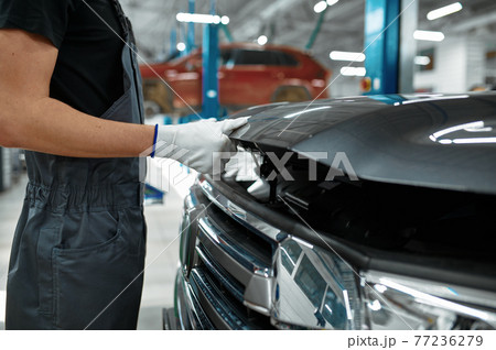 Male mechanic closes the hood, car service 77236279