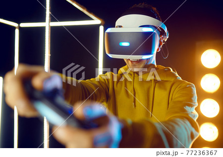 Man using virtual reality helmet and gamepad 77236367