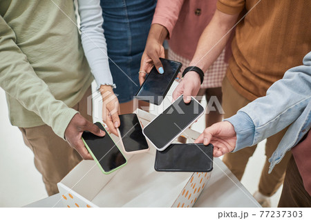 Students putting phones in box closeup 77237303