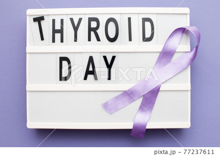 inscription international thyroid day and violet ribbon on purple background 77237611