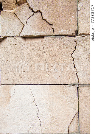 Cracks on the white wall blocks. The destruction of the wall. Background texture 77238717