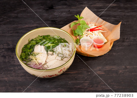 soup with chicken, onions, rice noodles, greens, served with soybean sprouts and Chilean pepper 77238903