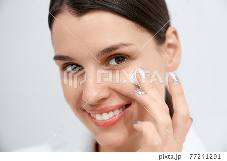 Happy woman moisturize skin special face cream at home.  77241291