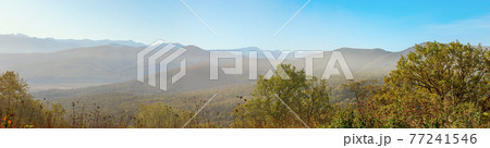 Range of mountains in the soft haze of an early autumn morning 77241546
