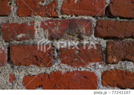 The wall of an old red brick building. 77242107