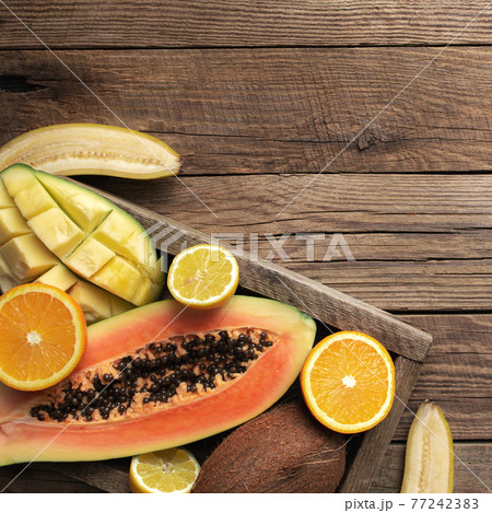 Fresh tropical fruits in a wooden box on a wooden background Fresh tropical fruits in a wooden box on a wooden background 77242383