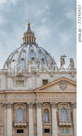 Dramatic view over Saint Peter Basilica in Vatican city, in the center of Rome, Italy, with heavy clouds. 77243437