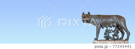 Banner with a monument of a mother wolf feeding enfants, Romulus and Remus at Rome, Italy, with copy space and blue sky gradient background. Banner with a monument of a mother wolf feeding enfants, Romulus and Remus at Rome, Italy, with copy space and blue sky gradient background. 77243441