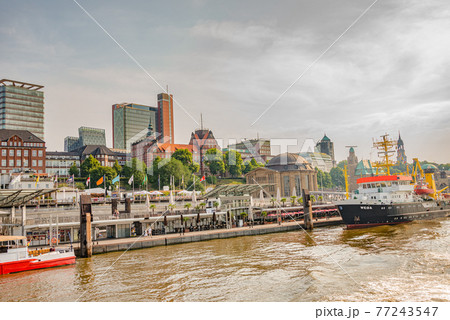 Busy port with many old and modern sailing boats and ships in Hamburg harbor during warm sunset, Germany 77243547