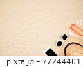 top view travel beach background concept with sunglasses ,smart phone , sunscreen and beach hat on sand. 77244401