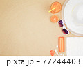 top view travel beach background concept with sunglasses ,orange juice , sunscreen and beach hat on sand. 77244403