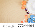 top view travel beach background concept with sunglasses ,orange juice , sunscreen and beach hat on sand. 77244404