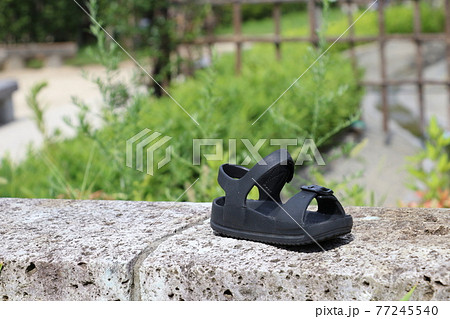 道端に置かれた片方のサンダル 落とし物のサンダルの写真素材  