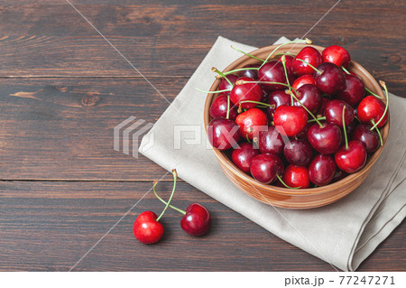 Cherry on plate bowl on wooden background. 77247271