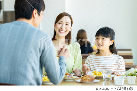 ファミレスで食事する若い家族 ファミレスで食事する若い家族 77249339
