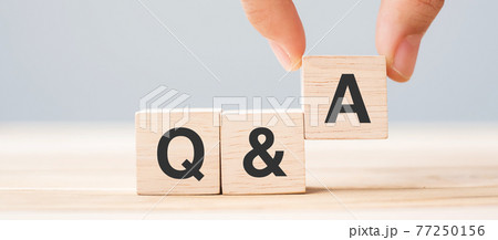 Hand holding Q and A word with wooden cube block. FAQ( frequency asked questions), Answer, Question  Ask, Information, Communication and Brainstorming Concepts 77250156