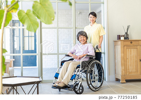 寄り添う若いヘルパーとシニア女性 77250185