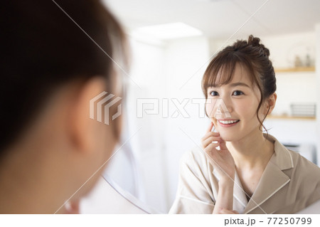 鏡を見るかわいい女性 77250799