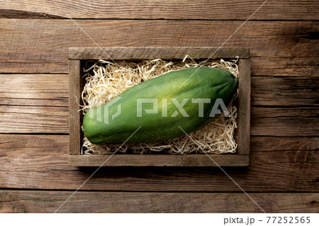 Fresh tropical papaya fruit in a wooden box on a wooden background 77252565