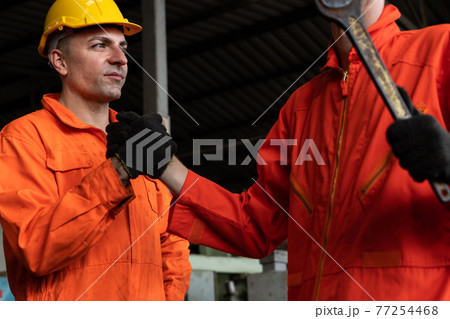 Two skillful factory engineer or worker showing teamwork and partnership . 77254468