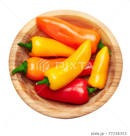 Wooden bowl full of Chili or sweet peppers isolated on white background Wooden bowl full of Chili or sweet peppers isolated on white background 77256353
